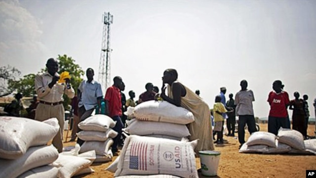 Southern Sudanese who recently returned from northern Sudan receive food rations from the World Food Program in the southern capital of Juba, 07 Jan 2011