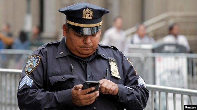 Một cảnh sát New York sử dụng điện thoại di động trong khi làm nhiệm vụ tại Manhattan, ngày 25 tháng 5 năm 2016.