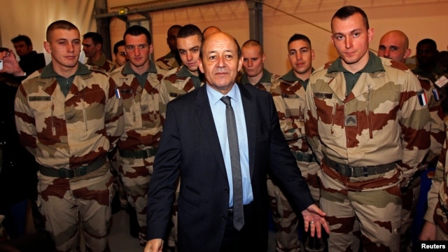 French Defense Minister Jean-Yves Le Drian (C) poses with French soldiers as they prepare to depart for Mali during a visit at the military base of Miramas, southern France, January 25, 2013.