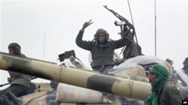 On this image taken during an organized trip by the Libyan authorities for a small group of journalists, Libyan soldiers loyal to Moammar Gadhafi's forces are seen on the western entrance of the city of Ajdabiya, Libya, Wednesday, March 16, 2011.