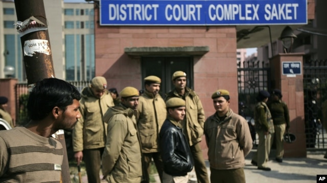 Delhi policemen stand guard near the gate of a district court where the accused in the gang rape and murder of a 23-year-old student are undergoing trial, in New Delhi, India, Jan. 24, 2013. 