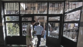 Lebanese citizens leave a destroyed building that was damaged during clashes erupted between pro- and anti-Syrian Sunni groups, in Beirut, Lebanon, May 21, 2012.