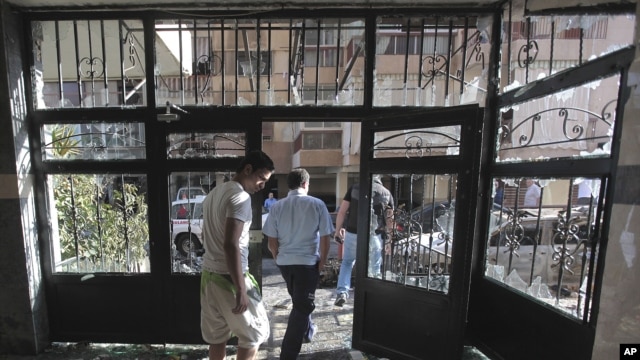Lebanese citizens leave a destroyed building that was damaged during clashes erupted between pro- and anti-Syrian Sunni groups, in Beirut, Lebanon, May 21, 2012.