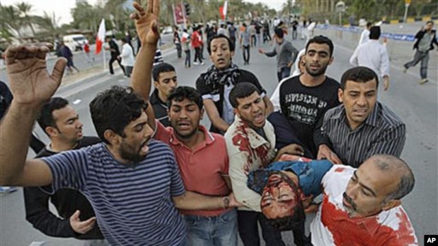 An unidentified Bahraini anti-government protestor is carried to a vehicle to be taken to a hospital after being wounded during a demonstration in Manama, Bahrain, February 18, 2011