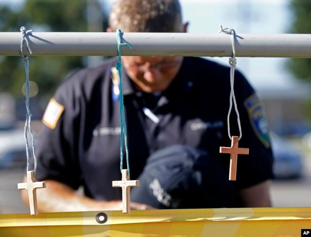 A police chaplain pays his respects July 18, 2016, at a makeshift memorial at the fatal shooting scene in Baton Rouge, Louisiana, where three law enforcement officers were ambushed and killed by a lone gunman on Sunday.