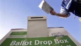 A voter drops off his ballot at a Washington state elections drop box outside of a north Seattle public library, Nov. 6, 2010