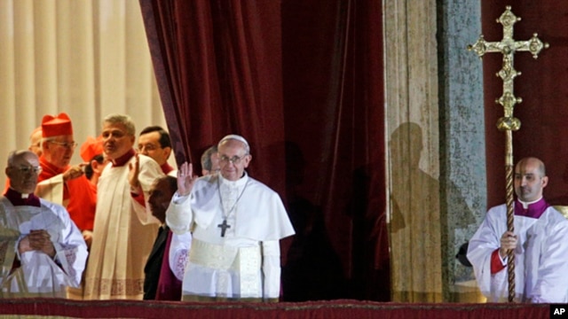 Pope Francis waves to the crowd from the central balcony of St. Peter's Basilica at the Vatican,  March 13, 2013. 