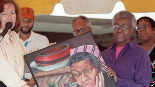 Gwendolyn Brooks, the first black person to win a Pulitzer Prize, holds a portrait of herself painted by artist Anne Cressey McGraw Beuchamp