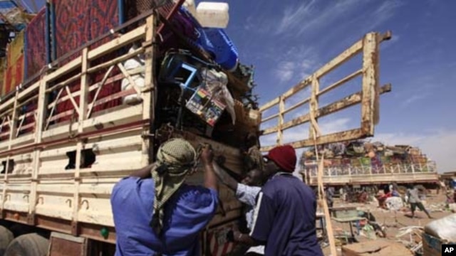 Southern Sudanese people in the north load their belongings on the truck as they prepare to leave for the south before the secession referendum, in an area called Mandela in Khartoum January 5, 2011