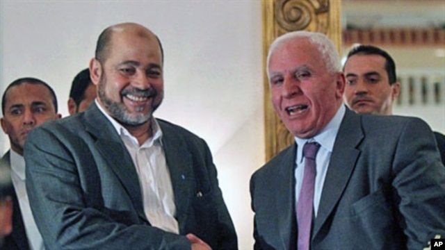 Palestinian Fatah delegation chief Azzam al-Ahmed (R) shakes hands with Hamas deputy leader Mussa Abu Marzuq after a joint press conference in Cairo on April 27, 2011 as rival Palestinian groups agreed to set up a transitional unity government and hold el