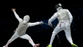 Suguru Awaji of Japan competes against  Andrea Cassara of Italy, right, in the gold medal match during the men's foil team fencing competition at the 2012 Summer Olympics.