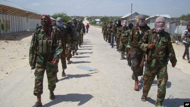 Members of Somalia's al- Shabab militant group patrol on foot on the outskirts of Mogadishu, March 5, 2012.