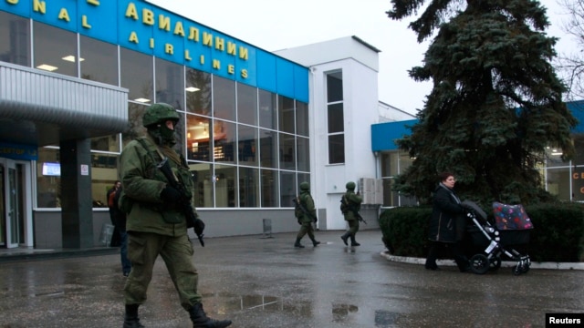 Armed men patrol at the airport in Simferopol, Crimea, Feb. 28, 2014. 