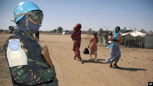Women with children near a member of Darfur's joint U.N./African Union UNAMID peacekeeping force, Darfur, Jan. 2011 (file photo).