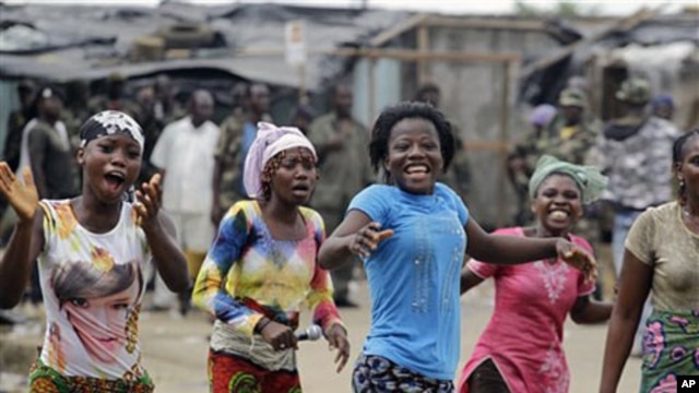 Local residents react to news of the capture of Laurent Gbagbo in the Youpougon neighborhood of Abidjan, Apr 11 2011