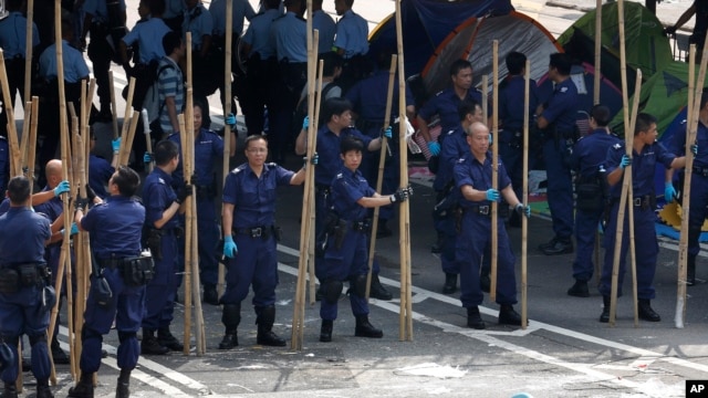 Cảnh sát dỡ bỏ các rào cản bằng tre do người biểu tình dựng lên để ngăn chặn con đường chính tại trung tâm Hồng Kông, ngày 14/10/2014.