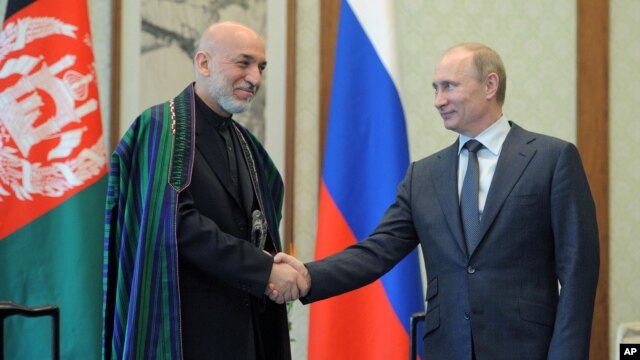Russian President Vladimir Putin (R) and Afghan President Hamid Karzai shake hands during a meeting in Beijing, China, June 7, 2012. 