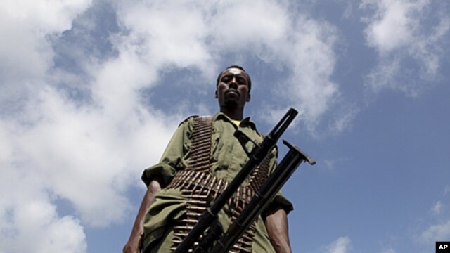 A Transitional Federal Government (TFG) soldier carrying a machine gun patrols the Indian Ocean coast-line in Burgabo, south of Kismayu in Somalia, (File).