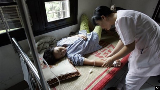 Una enfermera atiende a un paciente de dengue.