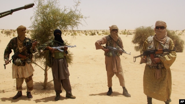 Ansar Dine fighters stand guard during hostage handover, outside Timbuktu, Mali, April 24, 2012.