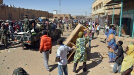 Malian troops try to dissuade the crowd from looting shops in Timbuktu, Jan. 29, 2013. Hundreds of Malians looted Arab-owned shops Tuesday in Mali's fabled Timbuktu, newly freed from Islamists.