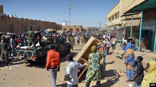 Malian troops try to dissuade the crowd from looting shops in Timbuktu, Jan. 29, 2013. Hundreds of Malians looted Arab-owned shops Tuesday in Mali's fabled Timbuktu, newly freed from Islamists.