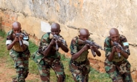 Somali government soldiers demonstrate their skills during their passing out ceremony at an army training camp in Uganda, Feb. 1, 2013.