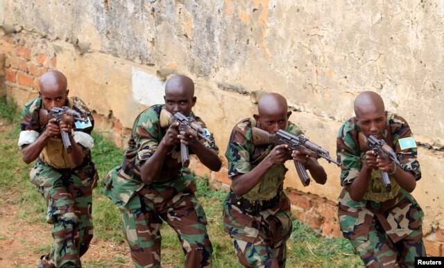 Somali government soldiers demonstrate their skills during their passing out ceremony at an army training camp in Uganda, Feb. 1, 2013.