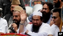 Pakistan's Hafiz Saeed, leader of a Pakistani religious group, center, waves during an anti-Indian rally in Lahore, July 19, 2016.