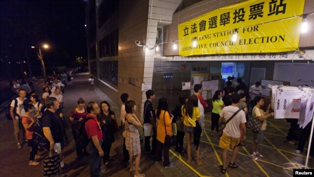 People queue as they wait to cast their votes at a polling station in Hong Kong on September 9, 2012.