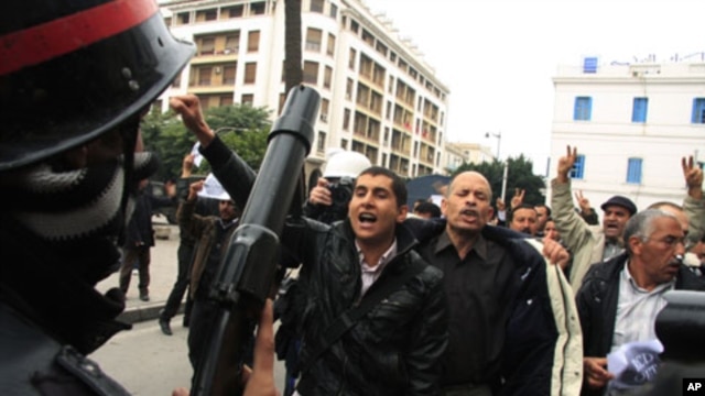 A riot policeman faces off with protesters during a demonstration in downtown Tunis, 18 Jan 2011
