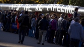 Demonstrators march with a replica of a pipeline during a protest to demand a stop to the Keystone XL tar sands oil pipeline outside the White House,  in Washington, Nov. 6, 2011.