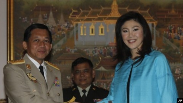 General Min Aung Hlaing (L), Supreme Commander of Burma's armed forces, shakes hands with Thailand's Prime Minister Yingluck Shinawatra during his visit to Thailand, at the Government House in Bangkok, January 10, 2012.