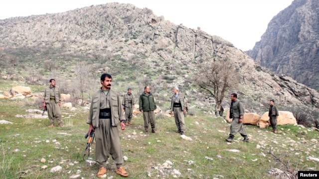 PKK fighters stand guard during the release of eight Turkish prisoners in the northern Iraqi city of Dohuk, March 13, 2013. (Reuters)
