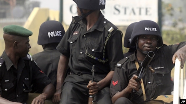 Police watch as people protest after the government suddenly removing subsidies on gasoline prices in Abeokuta, Nigeria, January 5, 2012.