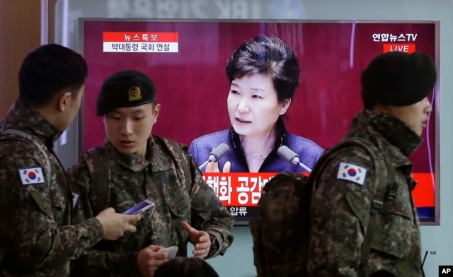 FILE - South Korean army soldiers pass by a TV screen showing the live broadcast of South Korean President Park Geun-hye's speech, at the Seoul Railway Station in Seoul, South Korea, Tuesday, Feb. 16, 2016.