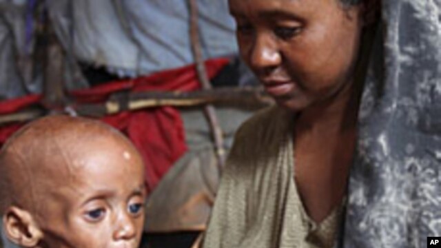 An internally displaced Somali woman holds her malnourished child inside their temporary home in Hodan district, south of Somalia's capital Mogadishu, September 20, 2011.