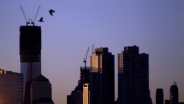 Dos pájaros vuelan a la salida del sol, con el fondo de la Torre Uno del Centro de Comercio Mundial, que podría convertirse en el edificio más alto de EE.UU., este lunes 30 de abril de 2012.