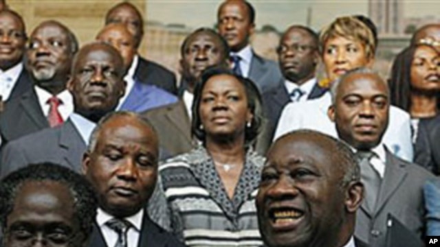 Incumbent President Laurent Gbagbo, center, gestures during a photo opportunity with his newly-named cabinet, with Prime Minister N'Gbo Gilbert Marie Ake, front left, at the presidency in Abidjan, Ivory Coast, Dec 7, 2010