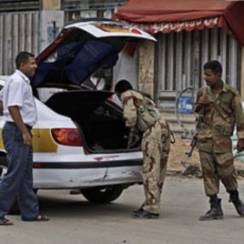 Yemeni army soldiers, check a car, at a checkpoint in Sana'a, June 11, 2011