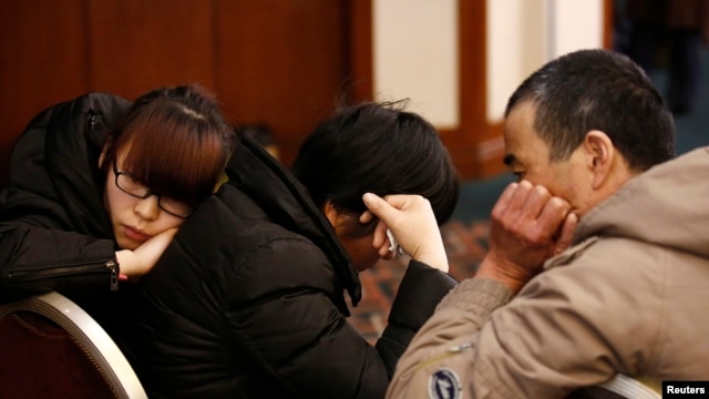 Family members of a passenger onboard the missing Malaysia Airlines flight MH370 react as they listen to a briefing from the airline company at a hotel in Beijing, March 18, 2014. 