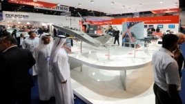 Visitors walk past a stand for Italian defence group Finmeccanica during the International Defense Exhibition and Conference (IDEX) at the Abu Dhabi National Exhibition Centre, February 19, 2013. 