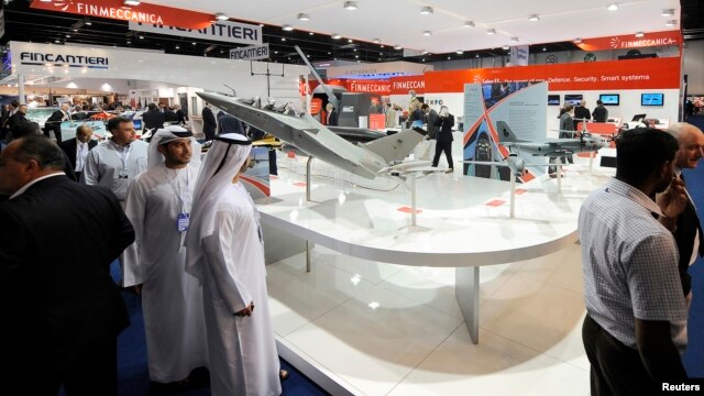 Visitors walk past a stand for Italian defence group Finmeccanica during the International Defense Exhibition and Conference (IDEX) at the Abu Dhabi National Exhibition Centre, February 19, 2013. 