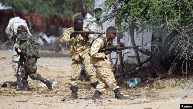Somali government soldiers open fire during an ambush by al-Shabaab rebels on the outskirts of Elasha town, May 29, 2012.