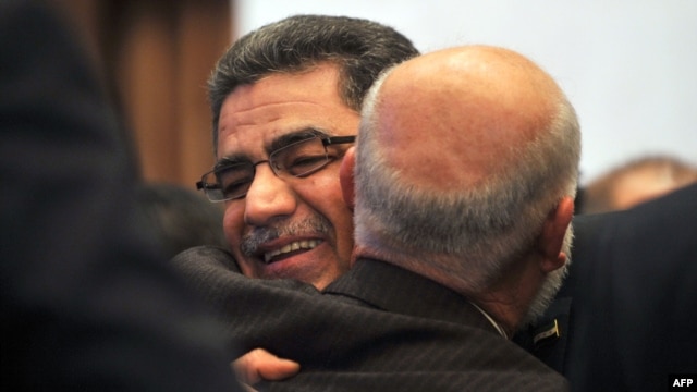 Syrian communications executive Ghassan Hitto (L), is congratulated late on March 18, 2013 in Istanbul after Syria's main opposition National Council elected him as prime minister.