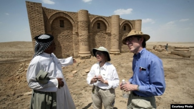 Laurie Rush and colleague Brian Rose at the ancient city of Uruk in Iraq, talking with Mr. Altubi, head of the family that protects the site. (Courtesy Laurie Rush)