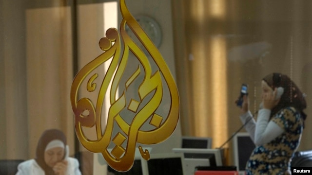 FILE - The Al-Jazeera logo is seen through a window at the offices of the Arabic news channel in Ramallah, West Bank, July 15, 2009. 