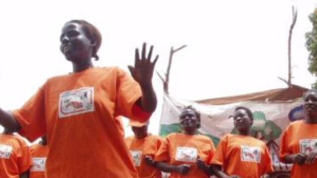 Orange-shirted women promote the health benefits of the orange sweet potato during a community performance in Uganda.