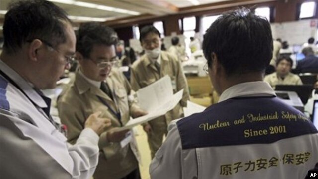 Teams of government and nuclear specialists at the emergency rescue headquarters analyze data from the leaked radiation from the Fukushima nuclear facilitiesin Fukushima, Japan, March 19, 2011