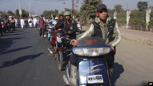 Indian journalists walk with their two wheelers at the funeral procession of fellow journalist Bwizamani Singh in Imphal, India, Tuesday, Dec. 25, 2012.